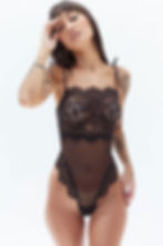 Garota usando um Body de tule e renda preto e sorrindo