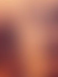 A foggy cityscape at sunrise, with skyscrapers shrouded in mist. Warm orange lights illuminate the buildings, creating a serene ambiance.