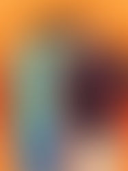 Two smiling people pose against an orange background. One wears a green shirt and cap, the other in a striped shirt and maroon cap. Relaxed vibe.