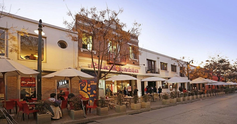 Street cafe with white umbrellas and seated people outside sign reading Ragio la vista at dusk, warm lights, calm mood