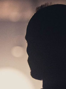 Silhouette of a person in profile against a soft, blurred light background. The atmosphere is calm and introspective.