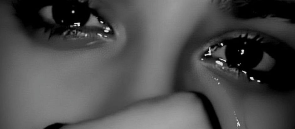 Close-up of tearful eyes with a tear streaming down, in a black and white image. The mood is somber and emotional.