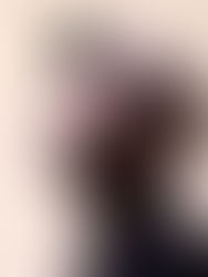 Man in profile wearing a beige cap and dark shirt, eyes closed, appears relaxed. Neutral background with soft lighting.