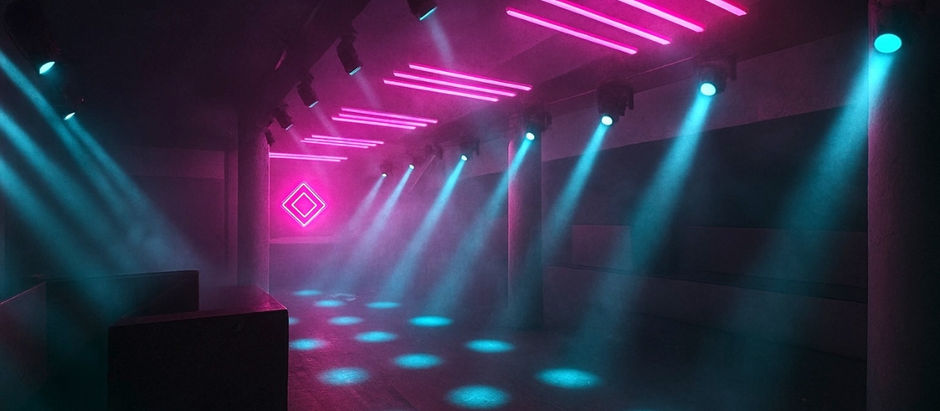 Dimly lit nightclub interior with pink and blue neon lights. Beams illuminate the foggy space, creating a vibrant and moody atmosphere.