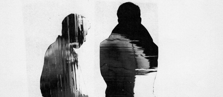 Abstract black-and-white image of two dark human silhouettes, one bowed, against a white background.