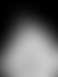 Person in a white shirt seen from behind, in a dimly lit setting. The image is black and white with a pensive mood.