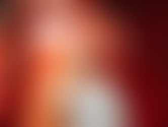 Man in light clothing, holding a red phone inside a red booth with "Appelle-moi" text. White balloons fill the booth, creating a festive vibe.