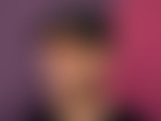 Man in a patterned black hat with "HUF" text, looking sideways against a purple and pink wall. Casual mood.