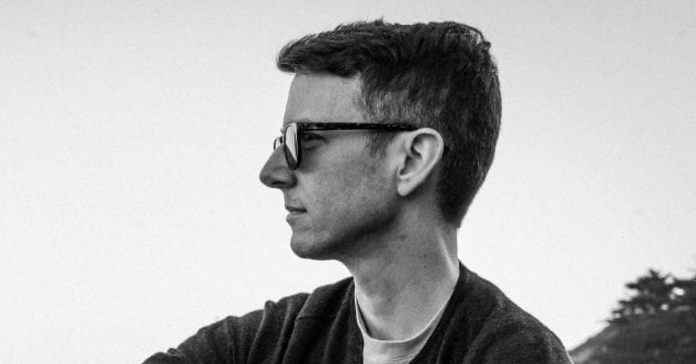 Profile of a person with sunglasses, looking peaceful. Black and white tone, with a clear sky and trees in the minimalist background.