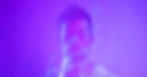 Man with closed eyes in a purple haze, wearing a white shirt. Dreamy, ethereal ambiance with soft, blurred light effects.