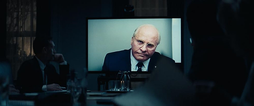 A shot of Dick Cheney on a video call in front of a dark room.