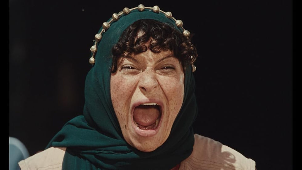 A woman in a hijab screams in close-up against a black backdrop.