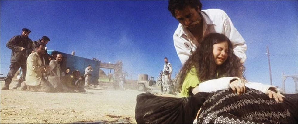A young girl sobs over a dead body in a desert as her father pulls her away in 'Three Kings'.