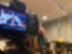 Behind the camera.