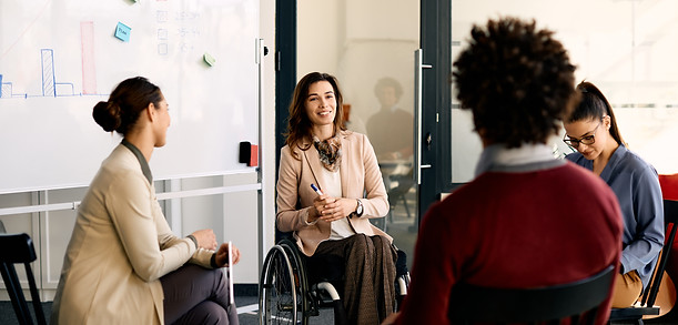 happy-disabled-businesswoman-brainstorming-with-he-2023-11-27-05-08-10-utc.jpg