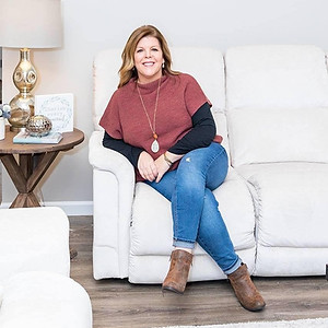 A photo of Stephanie Carter sitting on a white sofa