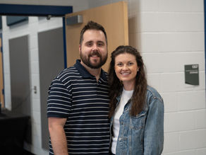 A married couple standing together smiling.