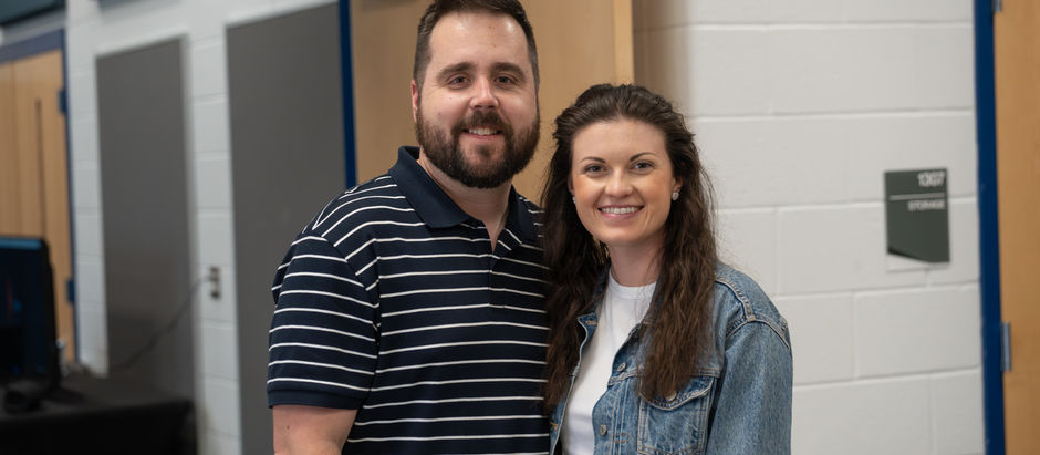 A married couple standing together smiling.