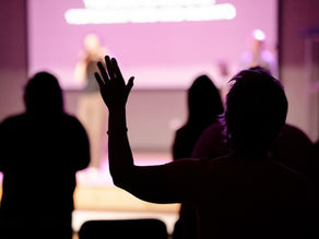 Woman raising a hand in worship.
