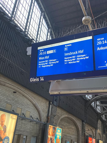eine Bahnhofsanzeige am Gleis, auf der ein Zug nach Wien angekündigt ist