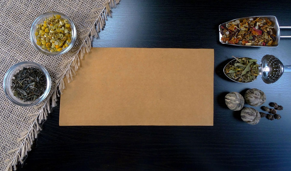 Loose botanicals and tea-making tools arranged for measuring and blending a custom cup.