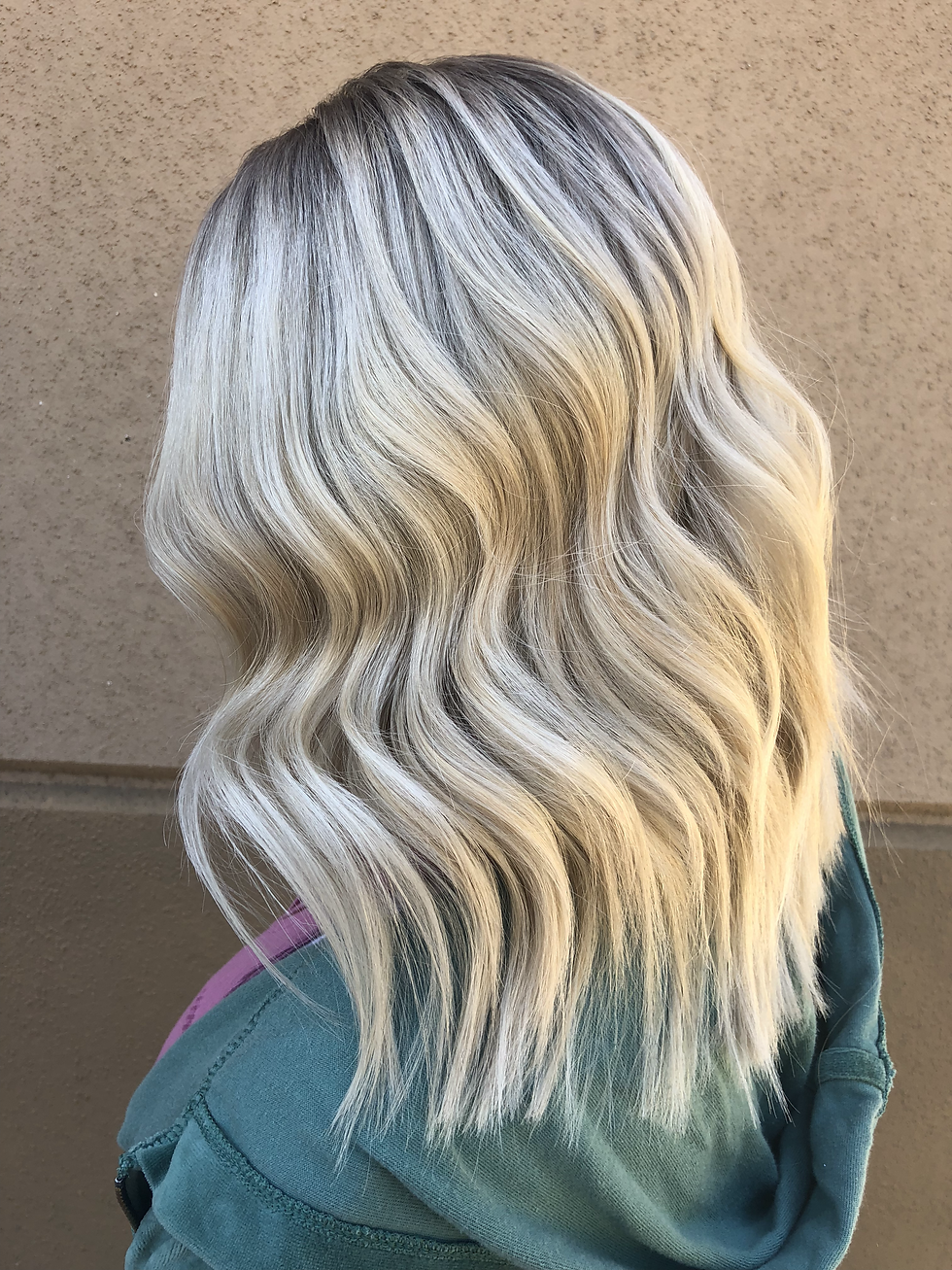 Side view of white blonde hair with root smudge.