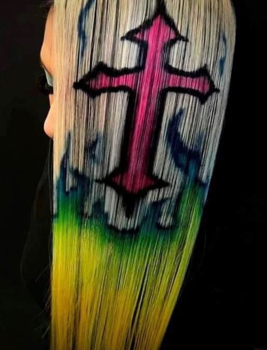 Side view of a girl with white blonde hair and a hot pink cross designed into her hair.