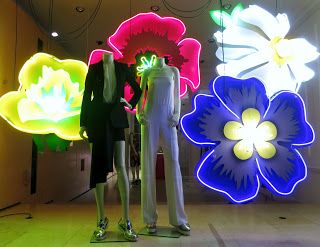 Vitrine incrível com flores gigantes super coloridas em neon