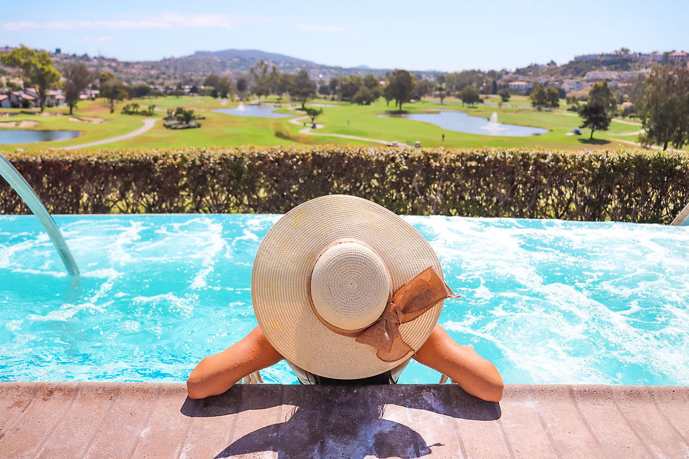 girl wearing a straw hat in a pool overlooking a golf course