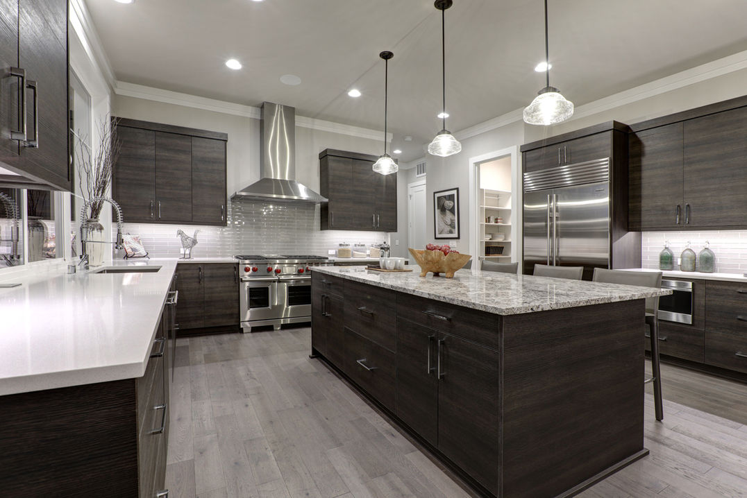 Modern gray kitchen features dark gray flat front cabinets paired with white quartz counte