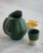 Still life photography — green ceramic jug gold candlestick marble surface
