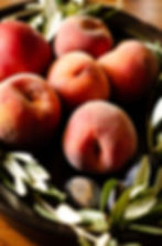 Still life food photography Provençale — peaches dark bowl olive branches