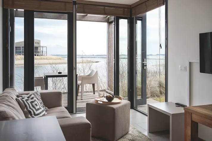 wohnzimmer ferienhaus wasserblick große fenster licht weite interieur fotografie