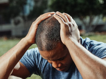 A frustrated person holding their head.