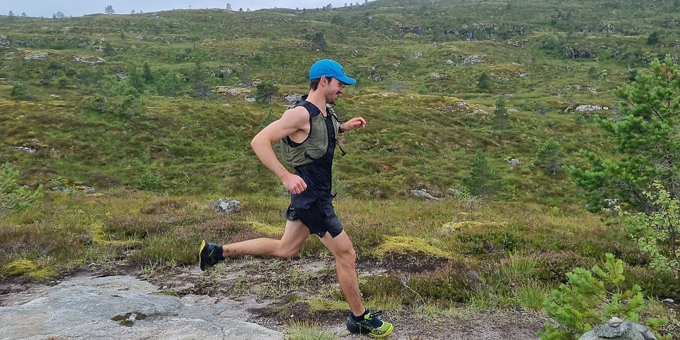 2Terrengløping i norsk fjellterreng – mann i løp oppover steinlagt sti med grønne åser i bakgrunnen.