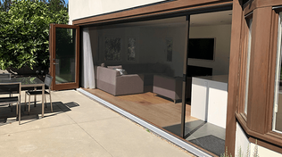 Large patio with custom sliding door with retractable bug screen by VistaShades