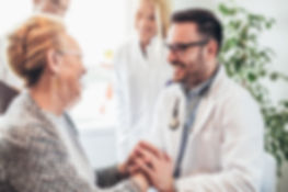 A doctor holding a patient's hands.