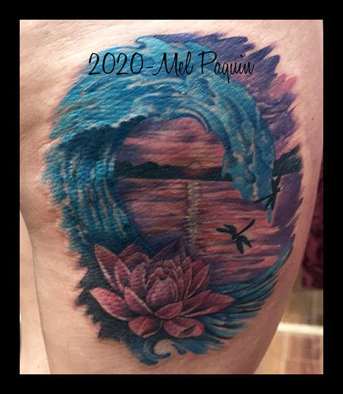 Tatouage de vague
bleue entourant un
lotus rose avec
coucher de soleil et
libellules. tatouage Gatineau tattoo 