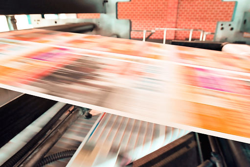 a photo of a printing machine with paper blurred as it goes through at high speed