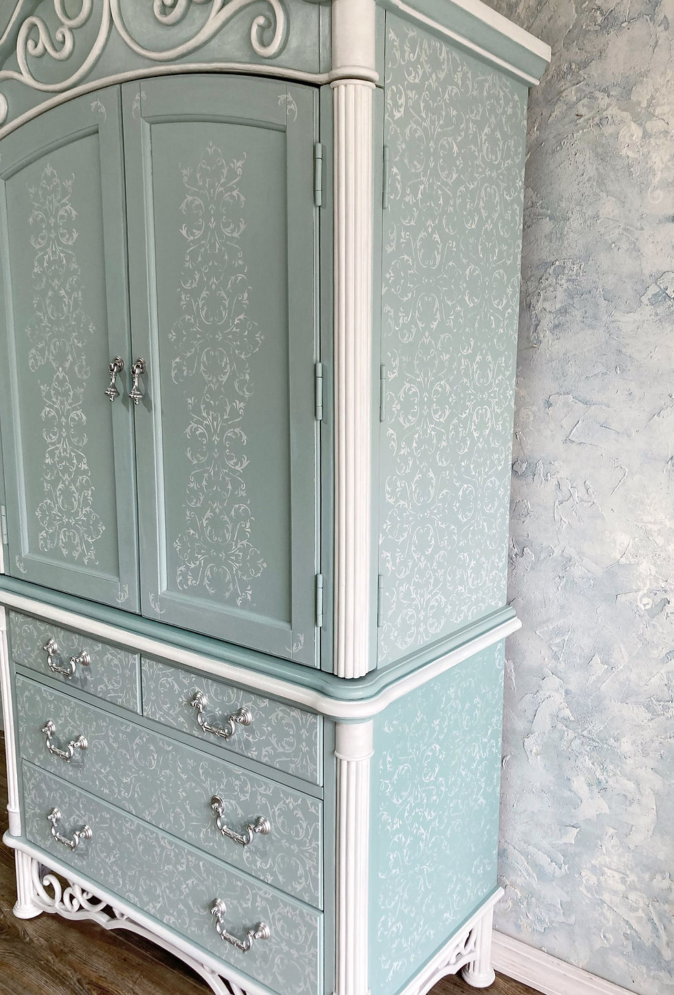 Thumbnail: A side view of the blue and white armoire showing the stenciling.