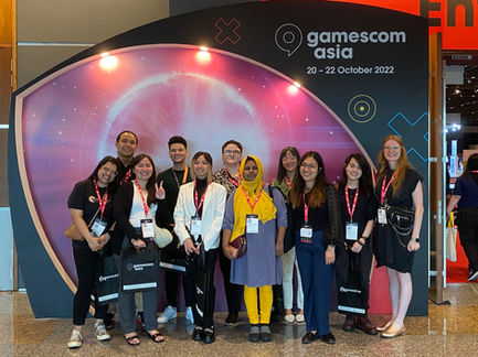 WIGI's Get in the Game Program mentors and mentees in front a backdrop that has says "gamescom asia, 20-22 October 2022. They were in Singapore for gamescom Asia.
