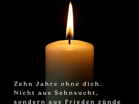 Eine weisse Kerze vor scharzem Hintergrund