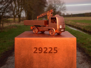 Kupferfarbener Miniatur-LKW auf Sockel