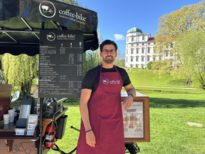 Dennis Seidel vor seinem Coffee Bike im Französischen Garten. Im Hintergrund das Celler Schloss.