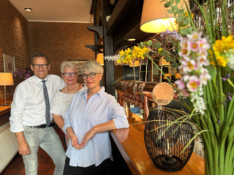 Die Betreiberfamilie steht im Gastraum an der Theke