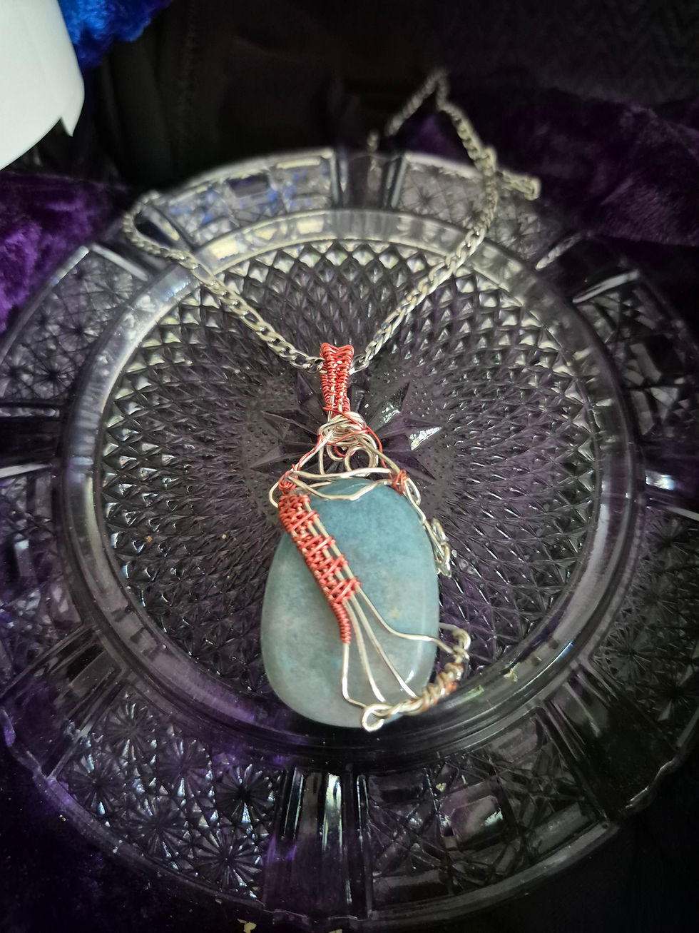 Thumbnail: Trolleite stone with pink wire wrap resembling staff paper or harp