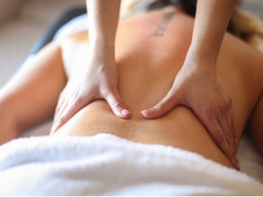 Woman receiving a soothing back massage in a calm, muted-tone spa environment.