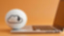 White cloud-download icon on a sphere beside an open laptop on an orange background, suggesting online downloading or cloud storage