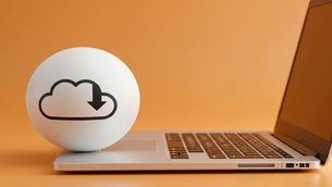 White cloud-download icon on a sphere beside an open laptop on an orange background, suggesting online downloading or cloud storage