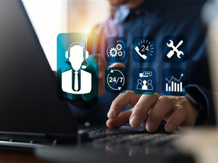 Hands typing on a laptop, surrounded by icons like 24/7 support, phone, and graphs. Blue-toned background, conveying technology focus.